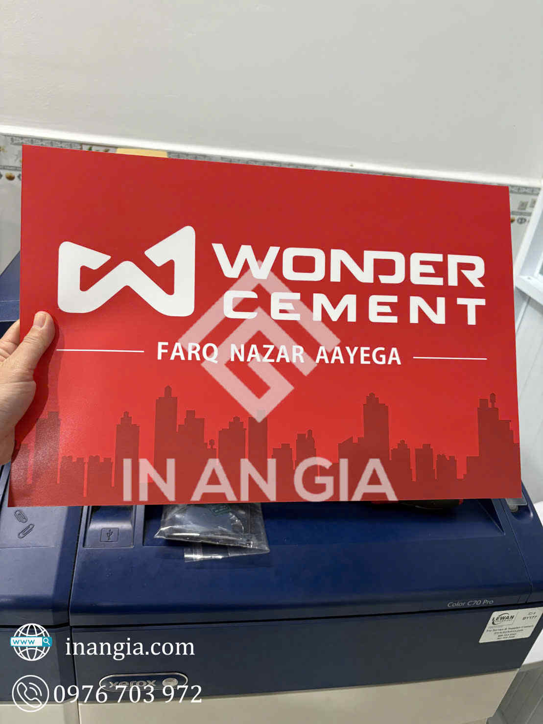Biển quảng cáo Wonder Cement nền đỏ với logo trắng và hình bóng tòa nhà in tại In An Gia