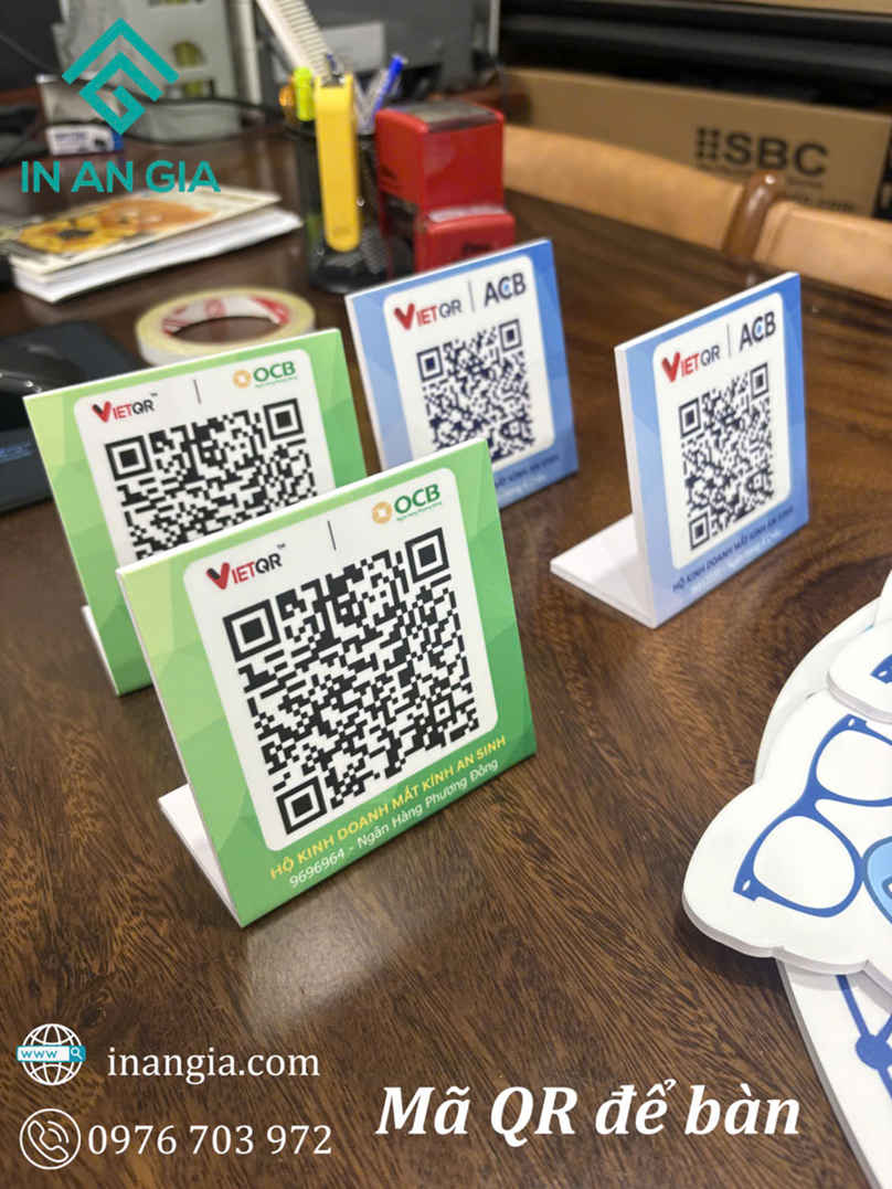 Biển mica mã QR VietQR OCB và ACB để bàn thanh toán trên mặt bàn gỗ văn phòng