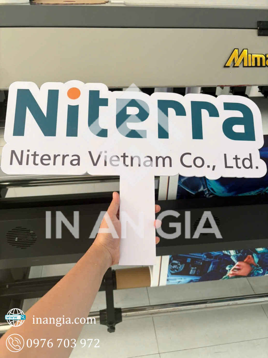 Biển cầm tay logo Niterra Vietnam Co., Ltd in màu, cầm trên tay trước máy in kỹ thuật số