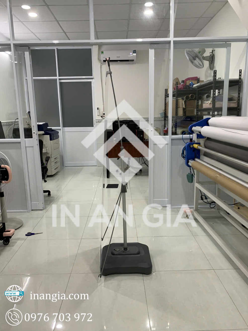 Giá treo banner chữ X chân đế nước đặt trong văn phòng in An Gia